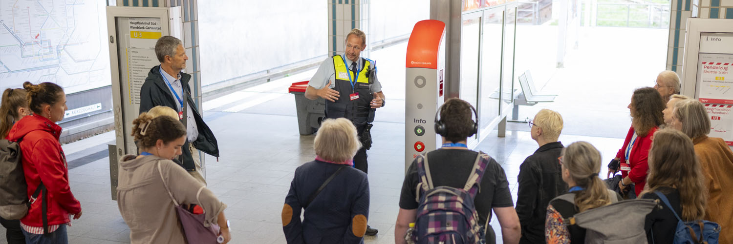 Teilnehmer vor einer Notrufsäule am Bahnsteig